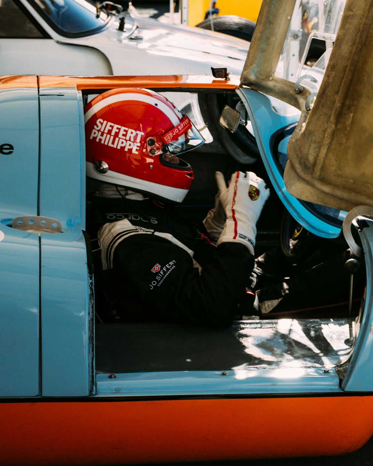 Racing helmet reflected in a car wing mirror